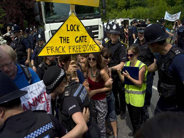 Demonstrators attempt to prevent police officers from escorting a lorry carrying oil drilling equipment to a site run by Cuadrilla Resources outside the village of Balcombe in southern England