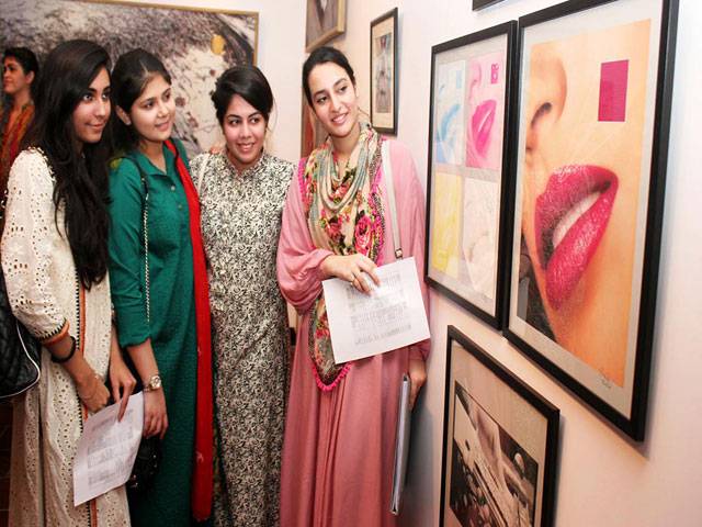 Students taking interest in the paintings displayed during an exhibition at Indus Valley School of Art & Architecture.