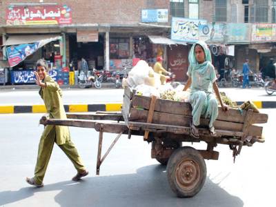 FAISALABAD: A boy pulling his cart while his sister sits on it after collecting valuables from garbage.–INP
