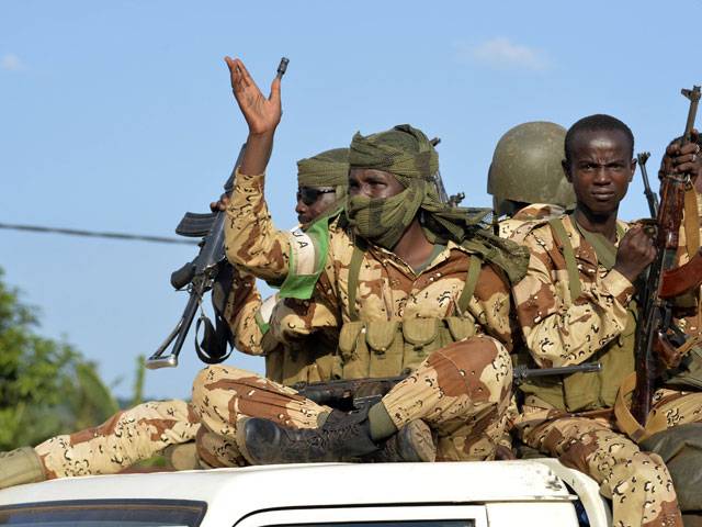 Chadian soldiers hold up their weapons