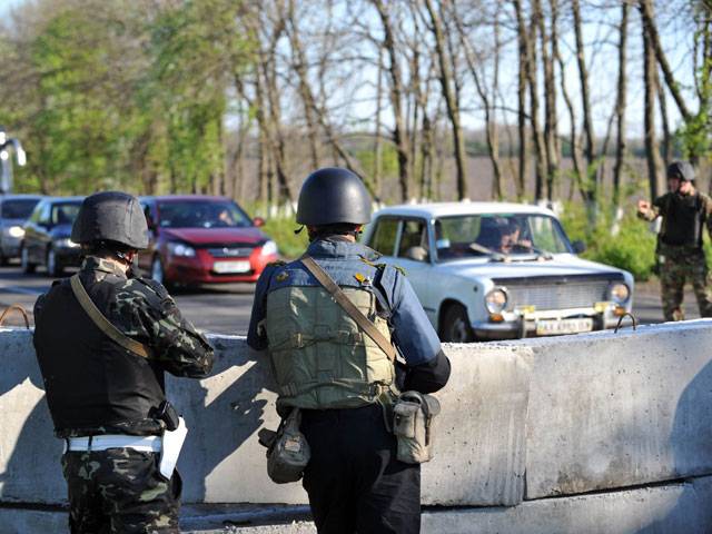 Ukrainian Policeman and soliders in a tanks stand guard
