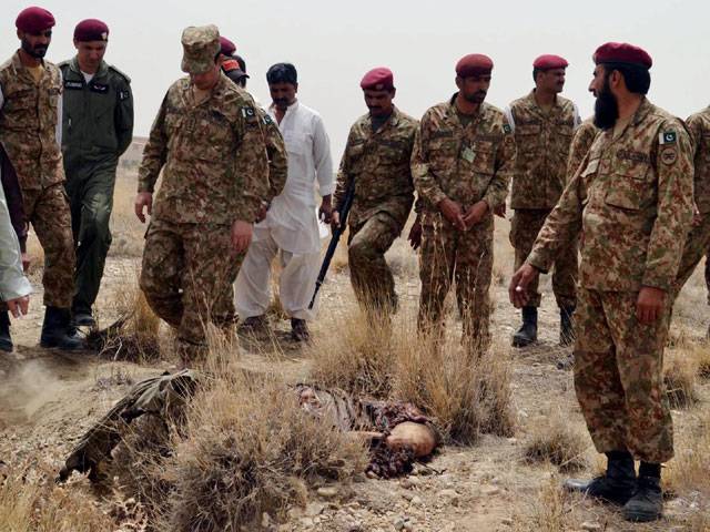 Pak Army officials stand beside the dead body of an attacker in Quetta