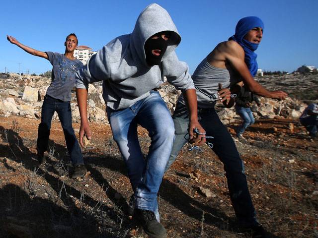 Palestinian demonstrators throw a stone Israeli security forces