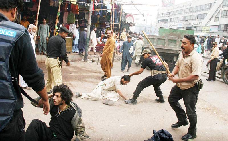 Policemen arresting the protestors anti-encroachment Saddar in Karachi