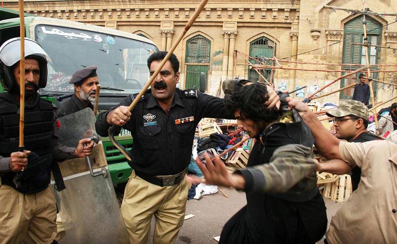 Policemen arresting the protestors anti-encroachment Saddar in Karachi
