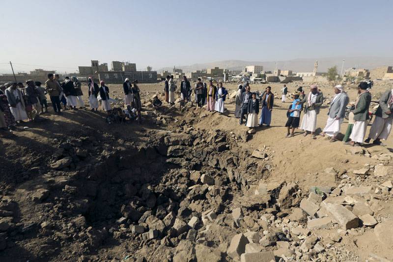  People stand on the rubble of destroyed house an air strike in Yemen
