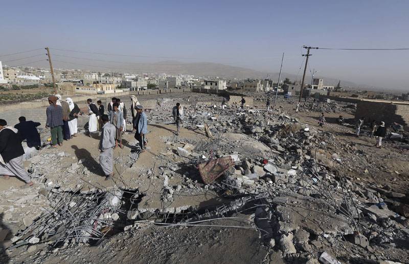  People stand on the rubble of destroyed house an air strike in Yemen