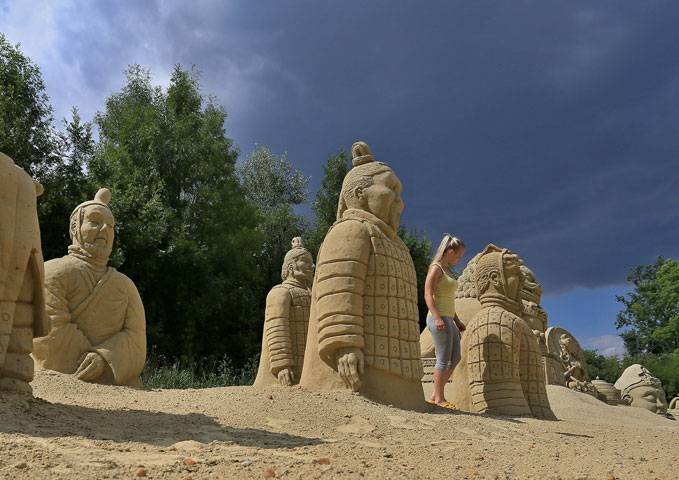 A visitor takes a photo of one of the sand sculptures in Czech Republic