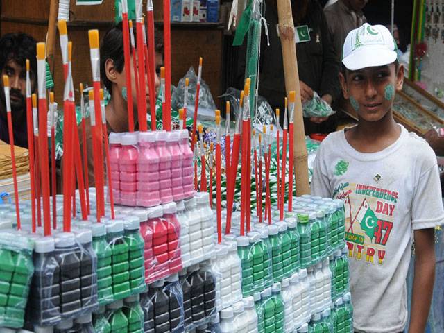 Displaying flags and other items for National Day celebrations in Urdu Bazar Lahore
