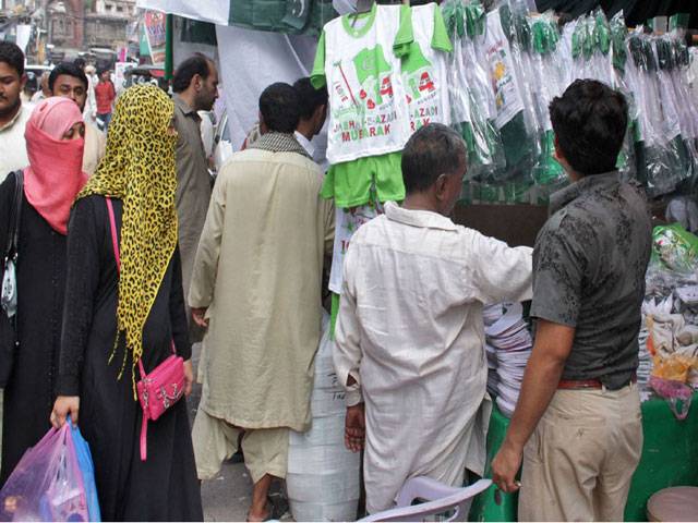 Displaying flags and other items for National Day celebrations in Urdu Bazar Lahore