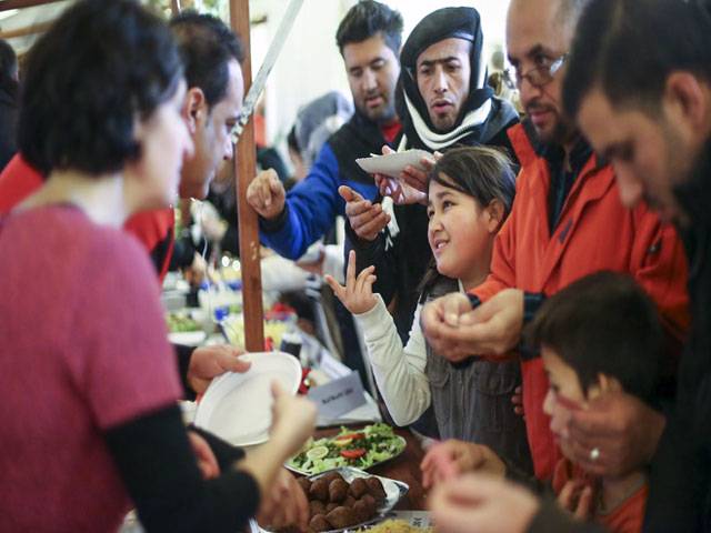  Migrants receive food at a Christmas market in Berlin