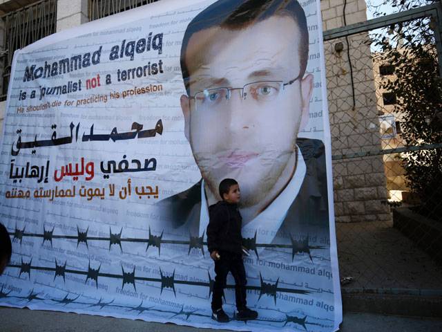 Palestinian imprisoned journalist flanked by her son addresses journalists during a press conference in Palestinian