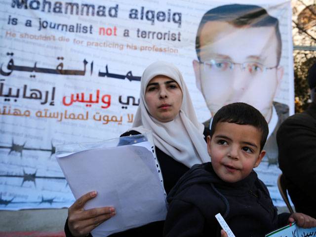Palestinian imprisoned journalist flanked by her son addresses journalists during a press conference in Palestinian