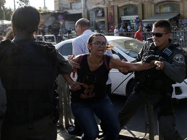 Policemen arrest a Palestinian protestor