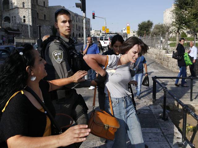 Policemen arrest a Palestinian protestor