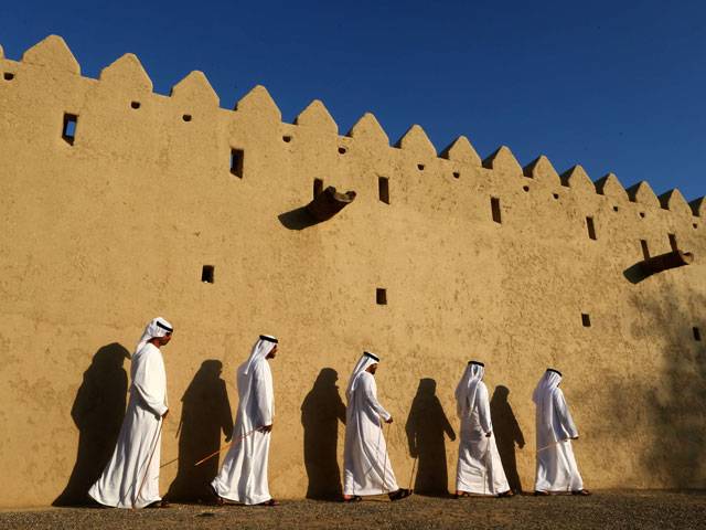 Emiratis walking past festival in al-Ain of Abu Dhabi