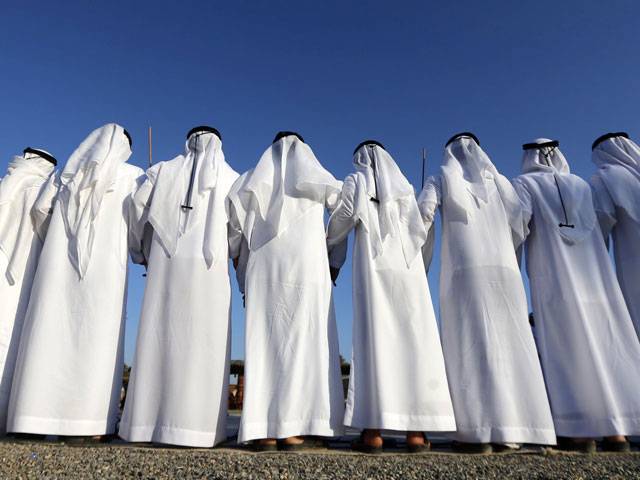 Emiratis walking past festival in al-Ain of Abu Dhabi