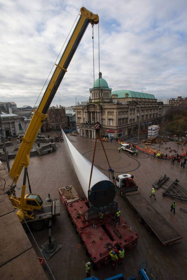 Workers manoeuvre the 'Blade' installation, a 75 metre-long hand-made fibreglass in UK