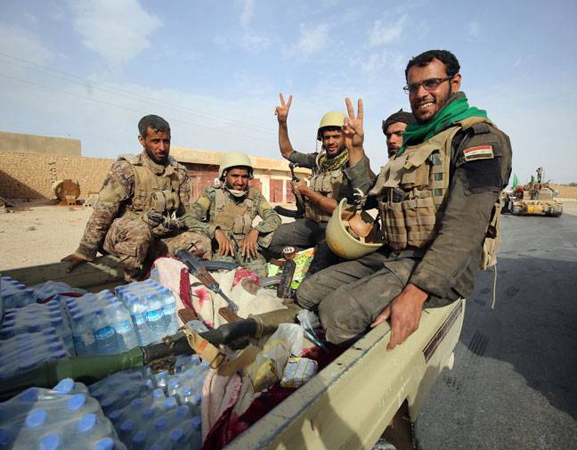 Iraqi forces and members of the Hashed al-Shaabi enter the city of al-Qaim, in Iraq
