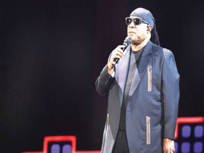 Stevie Wonder kneels as he leads anti-poverty concert